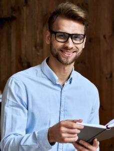 smiling-young-business-man-holding-planner-looking-2022-02-05-07-34-47-utc-1-228x300 (1)